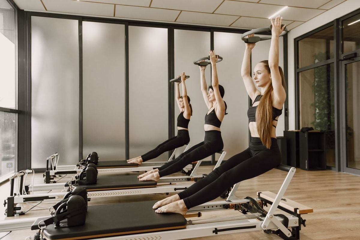 Grupo de mujeres haciendo pilates en máquinas reformer